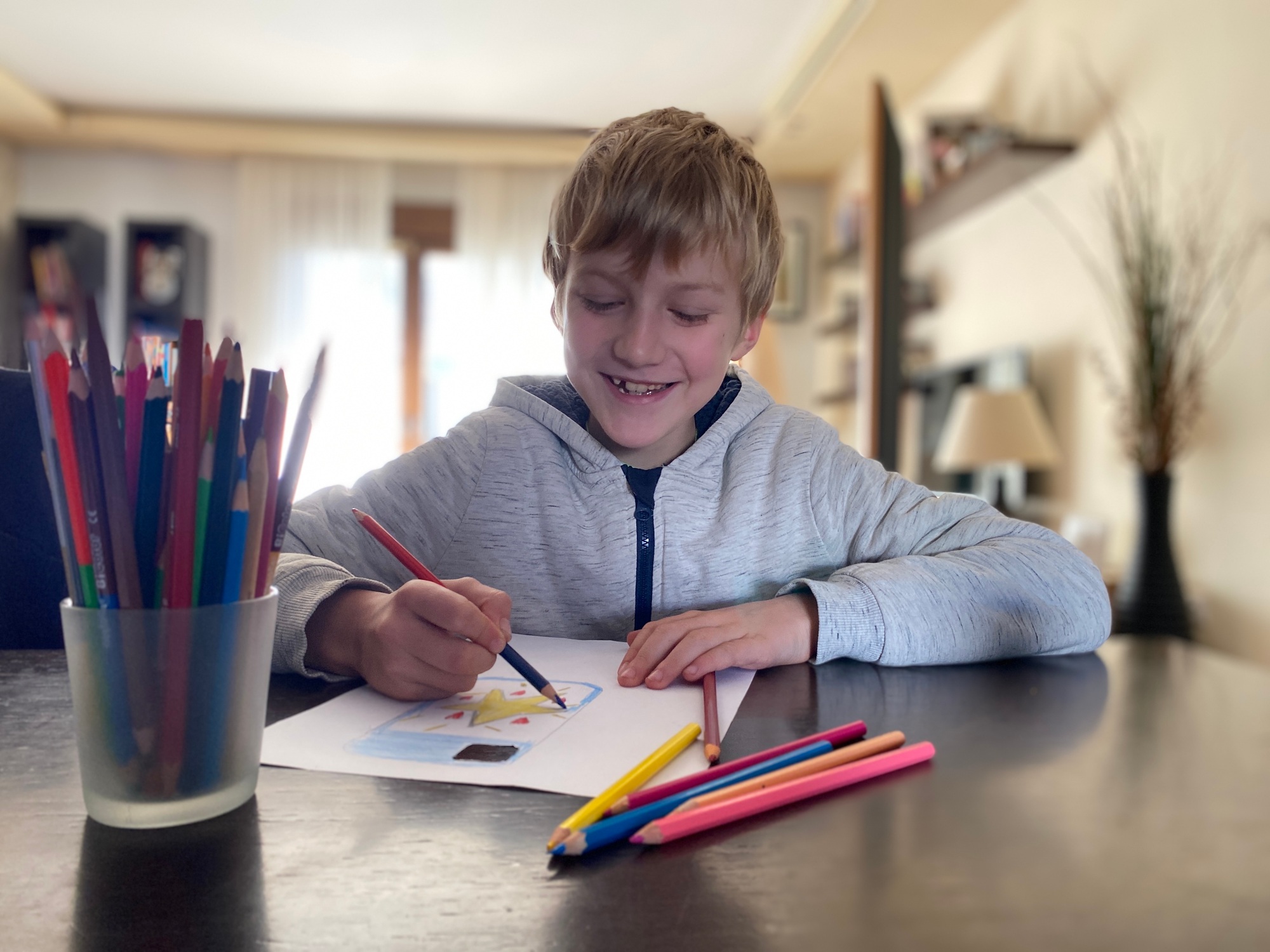 Boy 9 years old drawing with color pencils