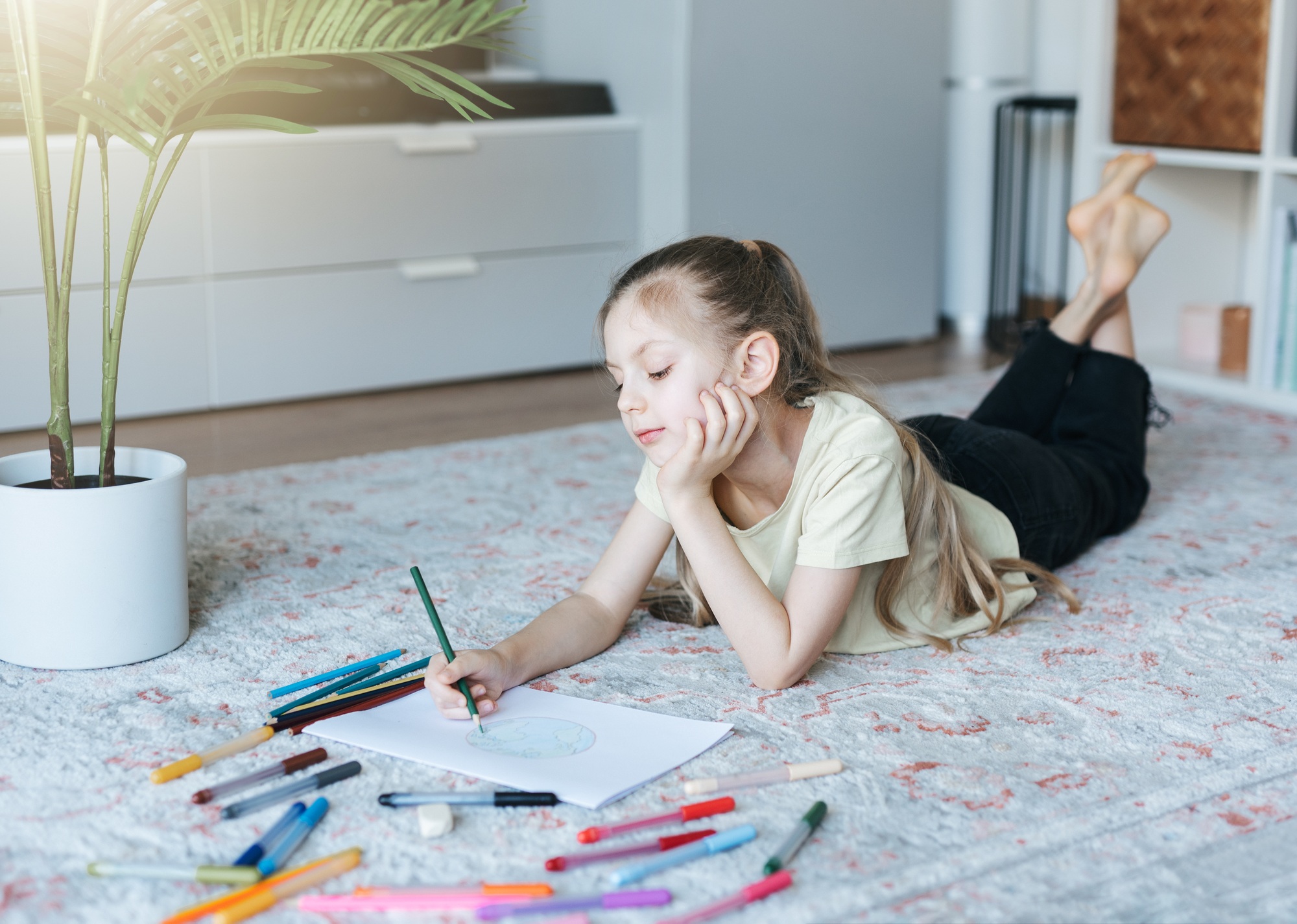 Child girl drawing with colorful pencils