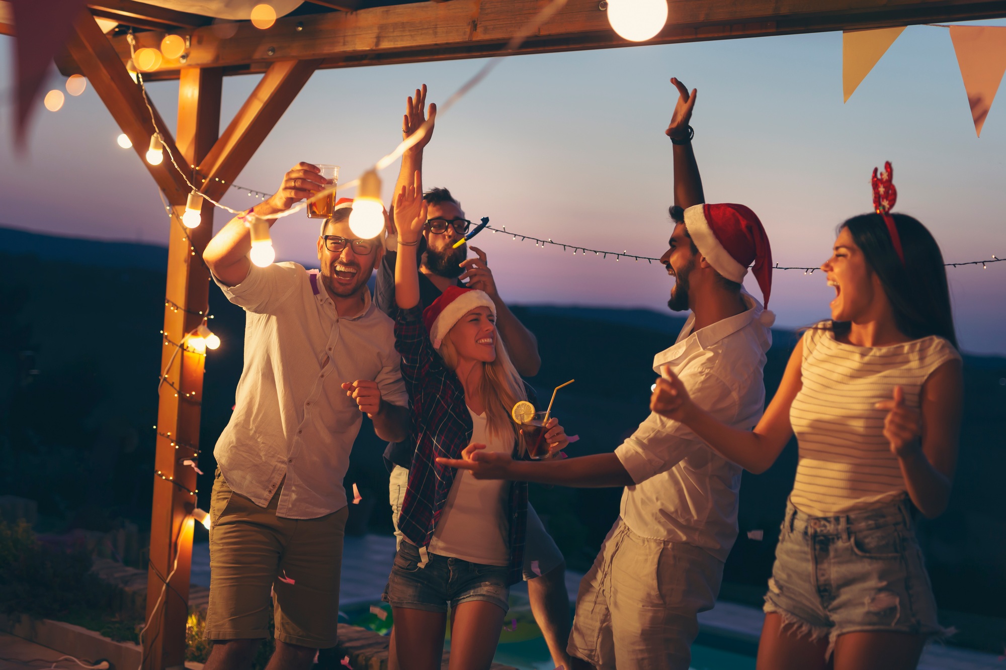 Friends dancing at poolside New Year's Eve party