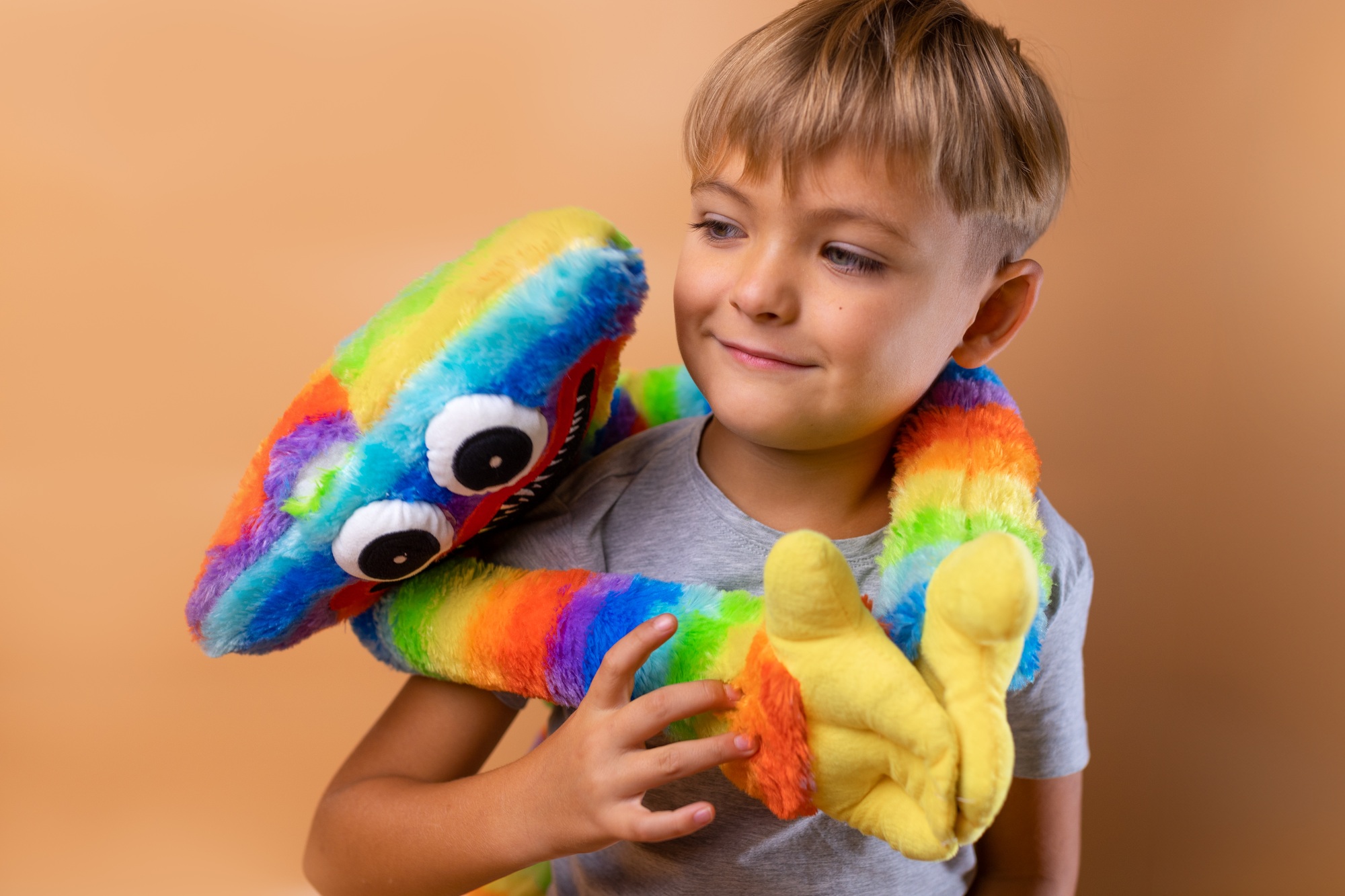 Positive little boy 6 years old with a bright colored toy. Concept: kindergarten, imaginary friend