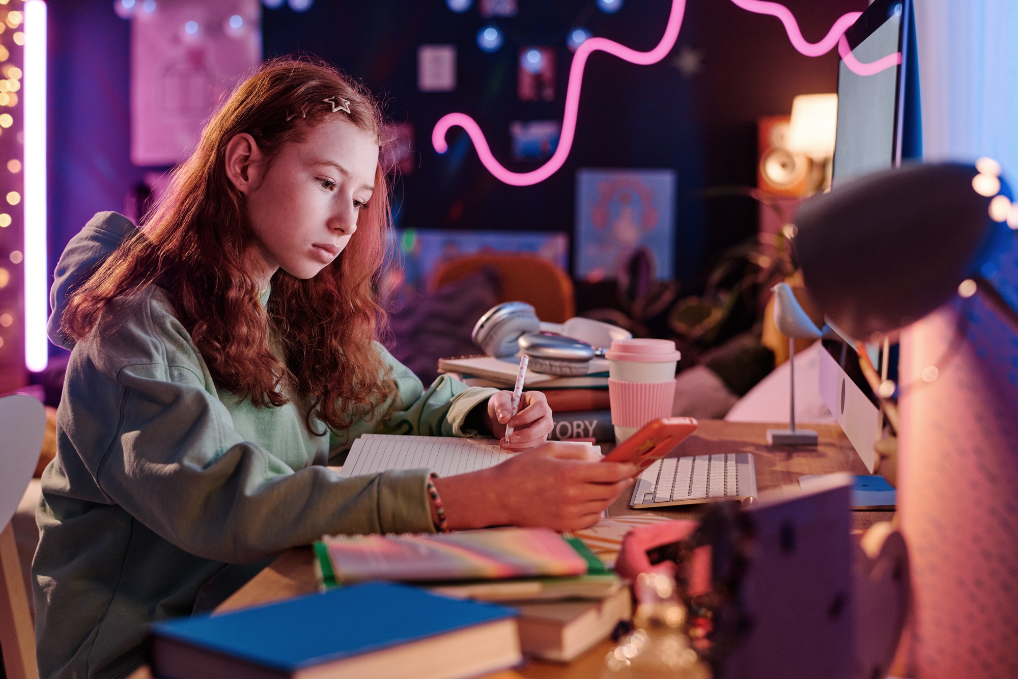 Teen Girl Using Smartphone While Doing Homework