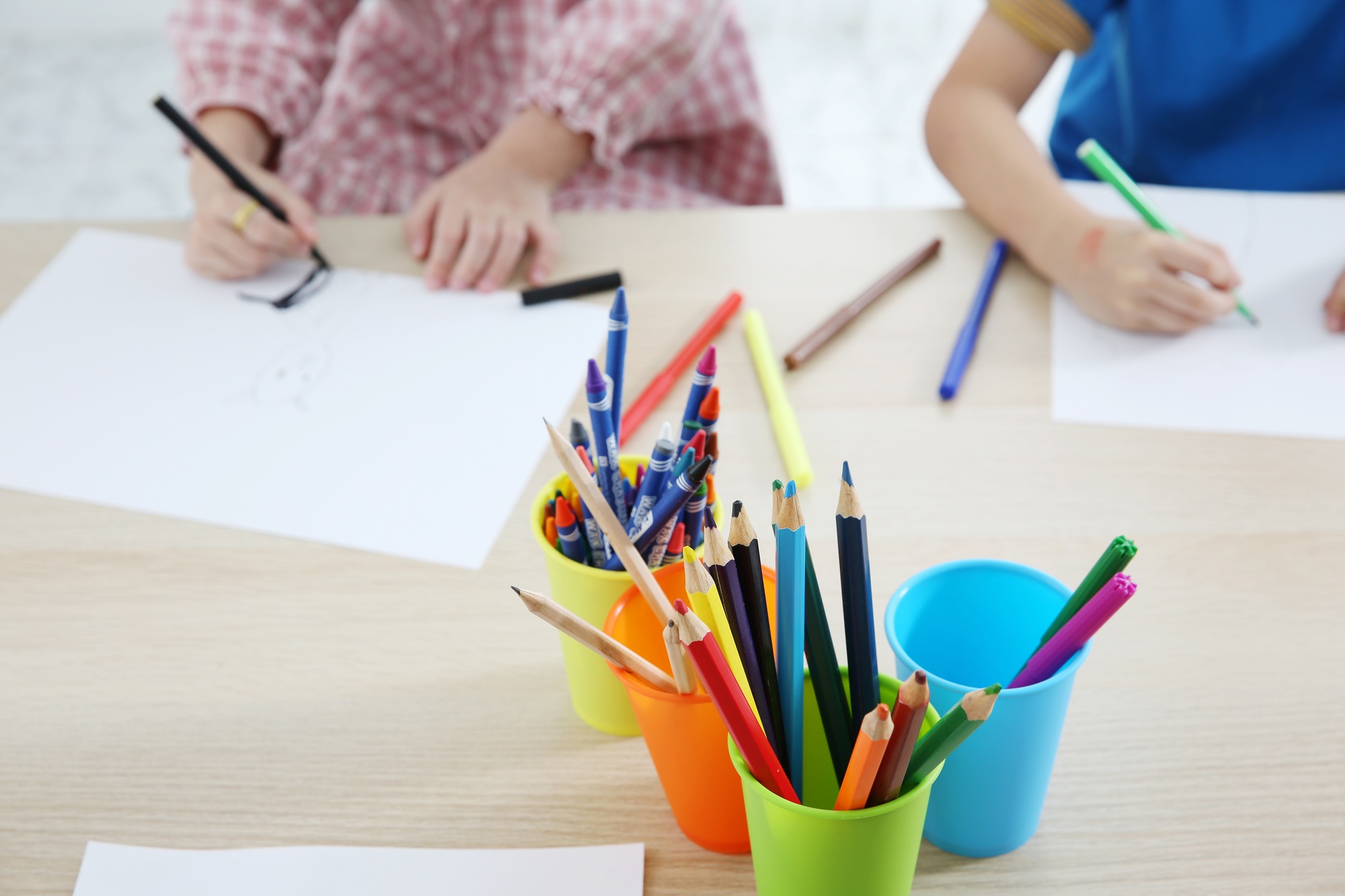 Together Asian preschool student do homework by drawing by a color
